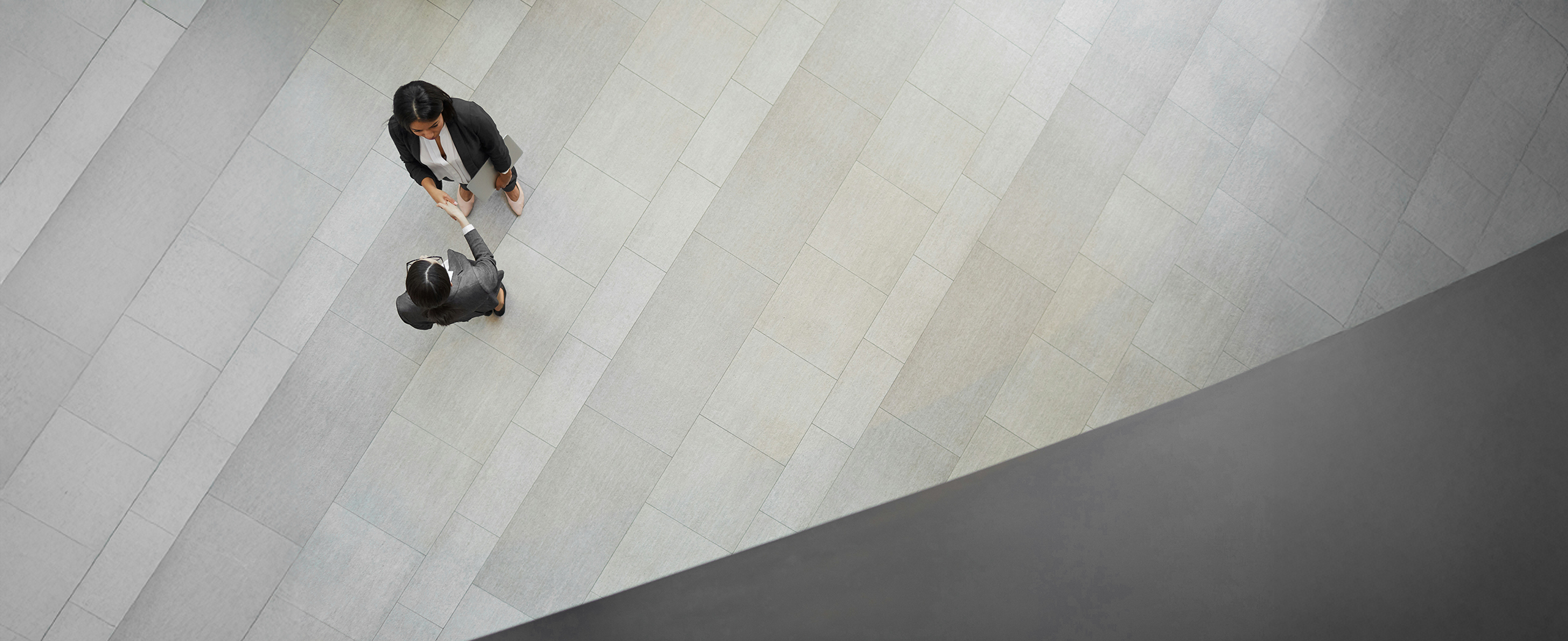 An aerial view of two professionals shaking hands making an agreement.
