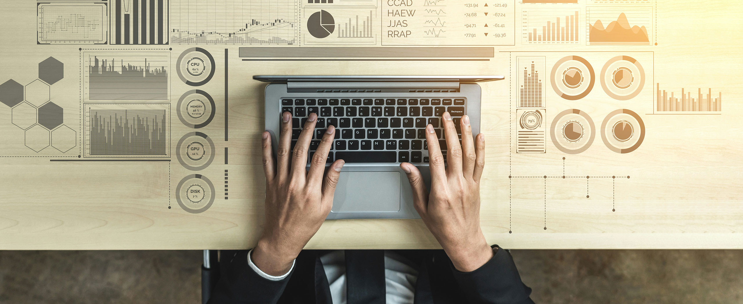 An aerial view of a person at a laptop surrounded by data charts. 