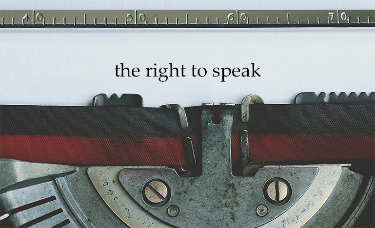 Closeup of a typewriter that just wrote "the right to speak".
