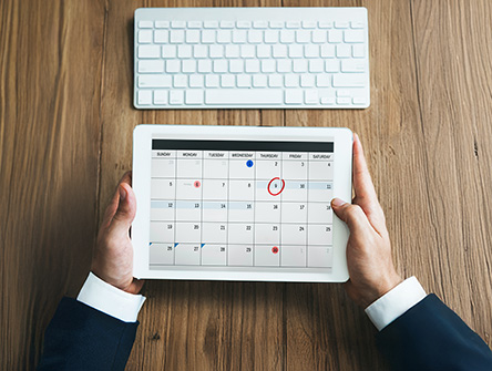 A professional holding a digital calendar.