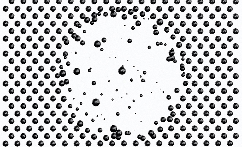 Black spheres on white background falling away in the middle