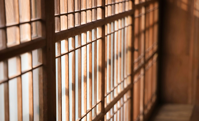 Prison bars with light shining through.