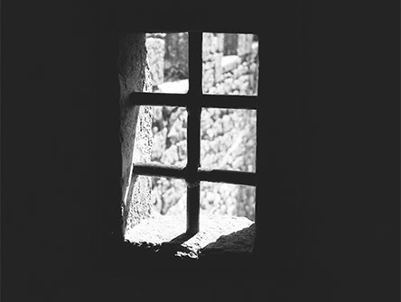 Light shining through the bars of a prison window.