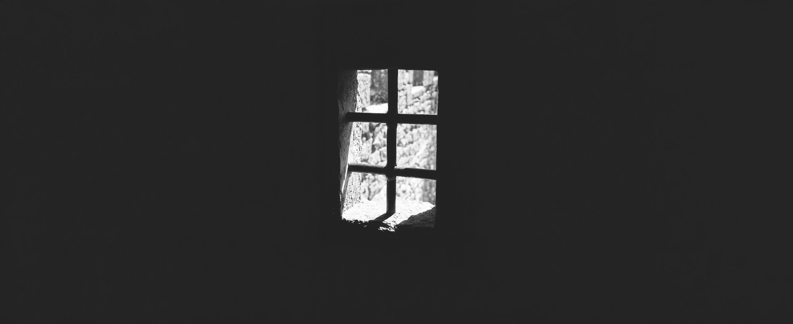 Light shining through the bars of a prison window.
