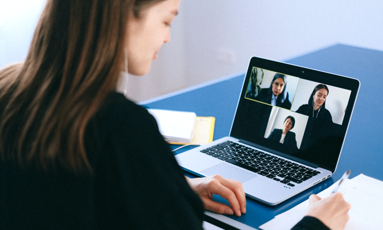Person in a video call on computer with three people on the screen