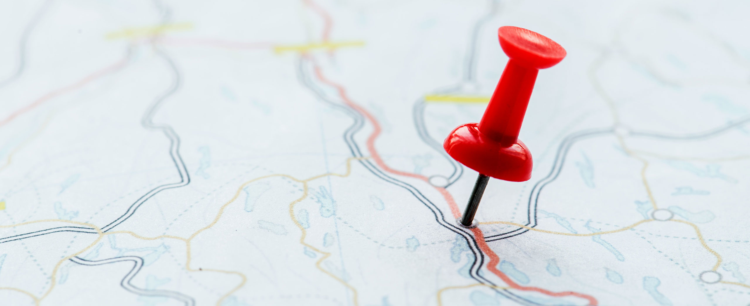 A push pin stuck in a map. 