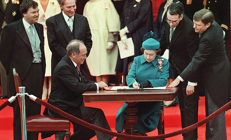 Queen Elizabeth II signing the Charter of Rights and Freedoms.