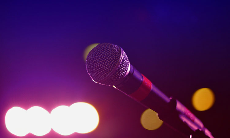 Microphone with a purple hue and spots of light in the background