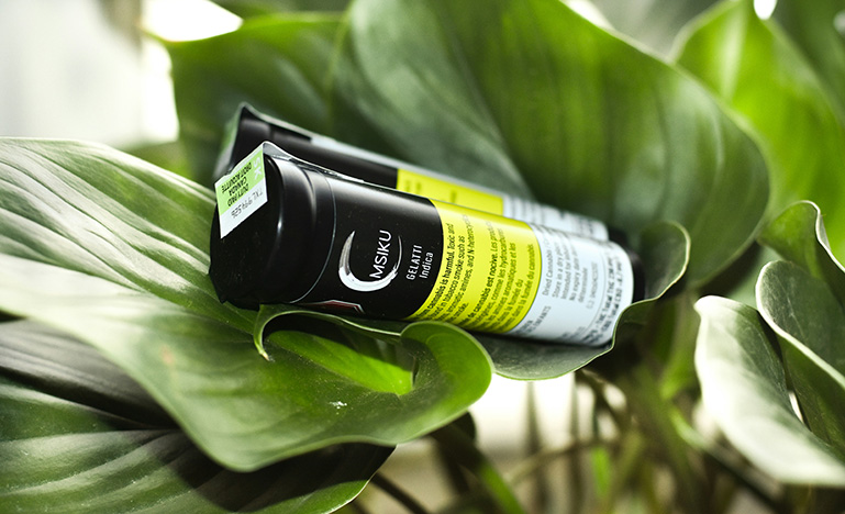 A canister of marijuana sitting on a leaf