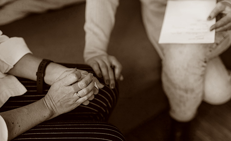 A professional putting their hand on their client who is in distress.