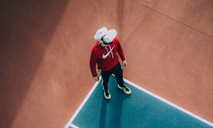 Person wearing a virtual reality headset standing on a tennis court