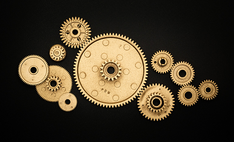 Gold gears in various sizes on a black background