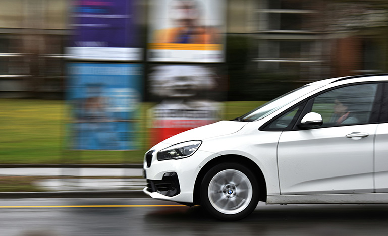 A person driving a car fast down a city street.