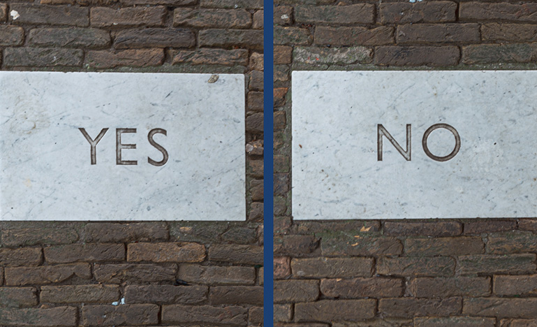 "Yes" and "No" written on brick wall