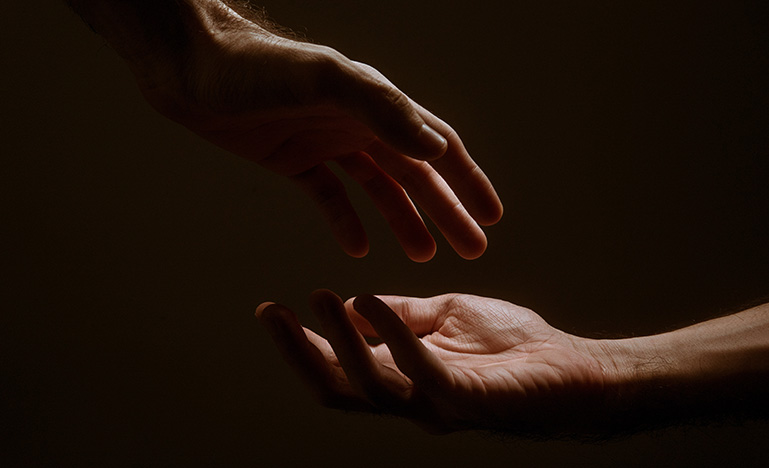 Two hands reaching for each other