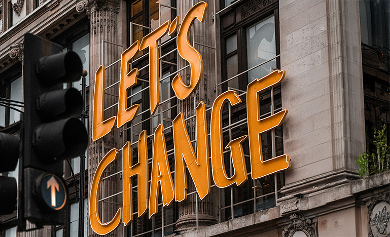A large sign on a building that reads "Let's Change"