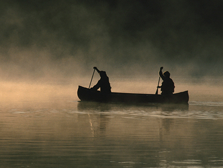 Two people paddling a canoe. 