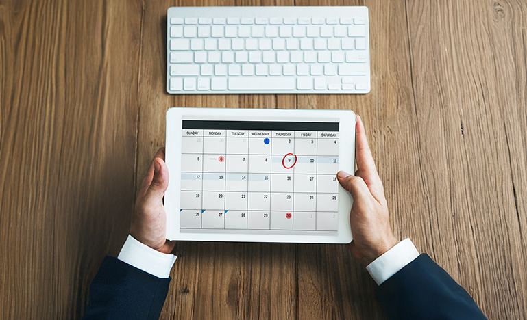 A professional holding a digital calendar.