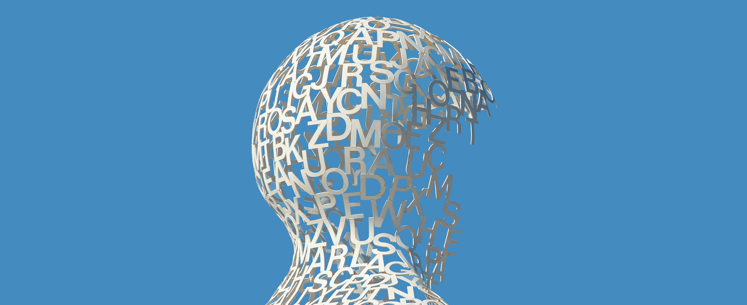 A sculpture of an unfinished human head comprised only of letters.