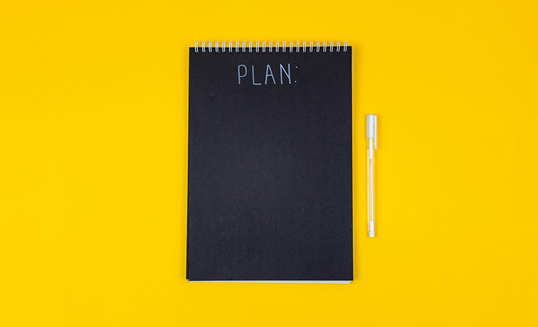 Black notebook on yellow background