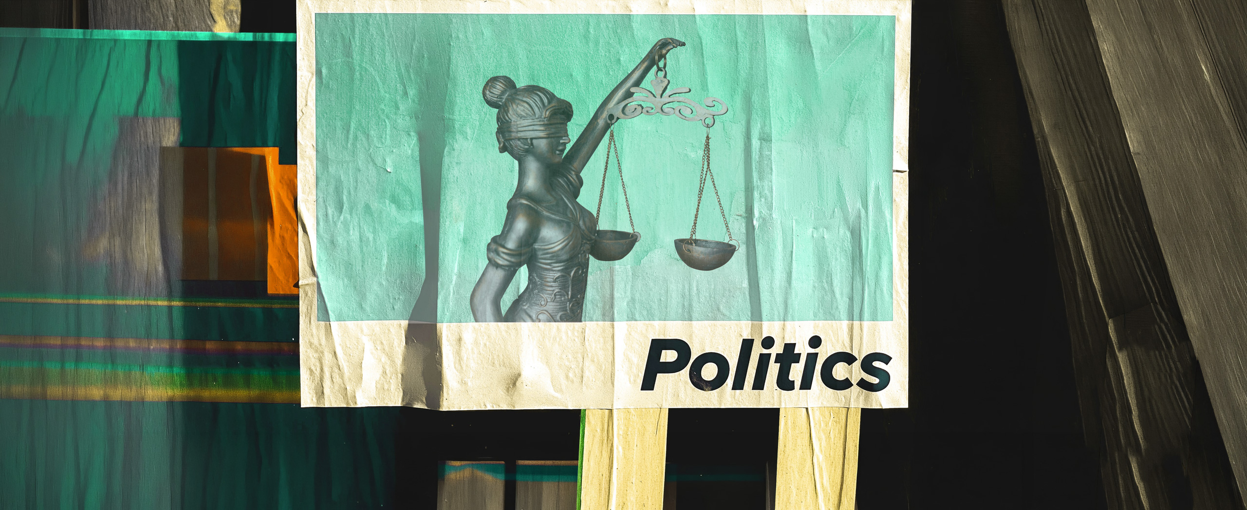 A street poster with the scales of justice and "Politics" on it.