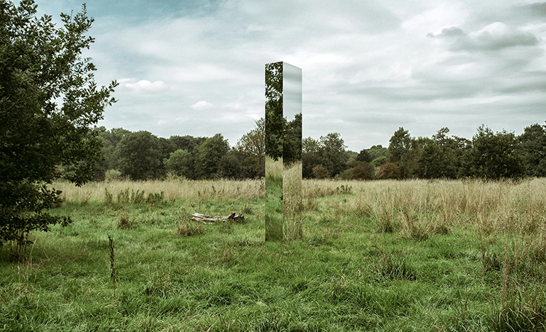 A rectangular mirror sculpture in the middle of a field