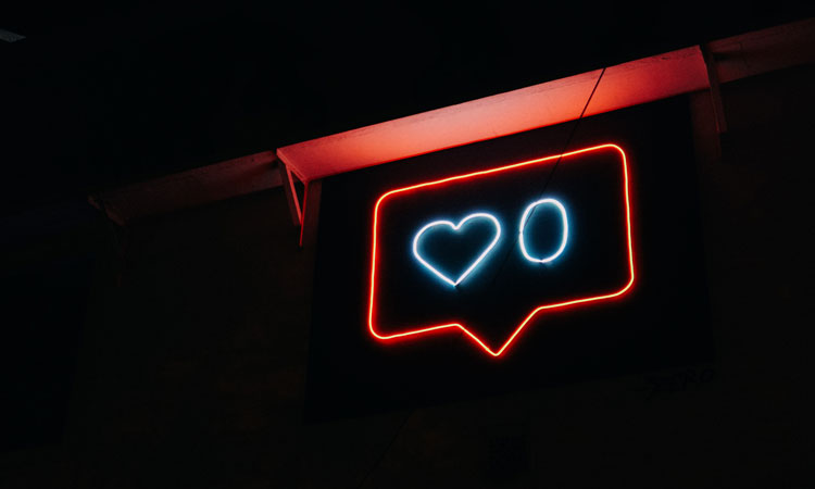 Neon sign of a red speech bubble with a heart symbol and the number 0 inside it