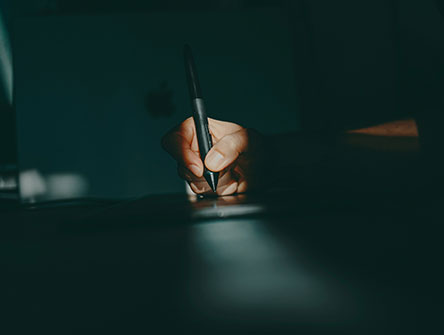Close up of a hand holding a pen, starting to write.