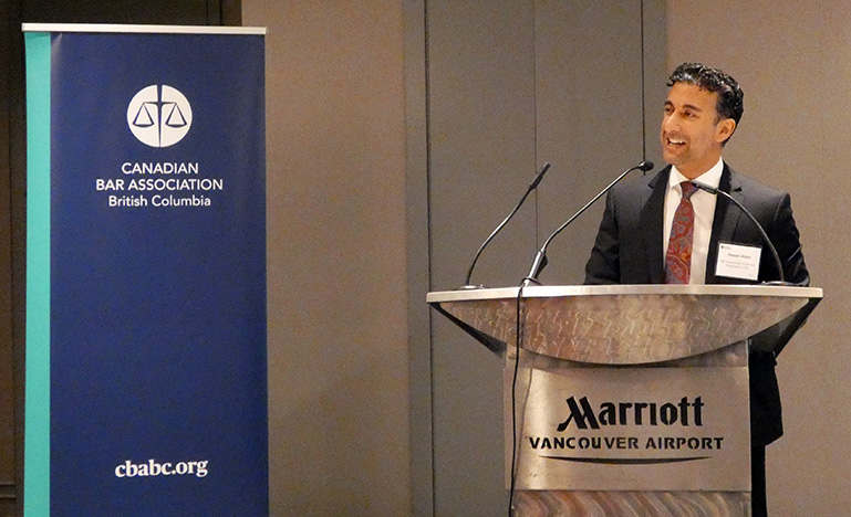 Hasan Alam making his acceptance speech at a podium.