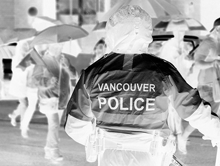 A Vancouver police officer standing in the rain.