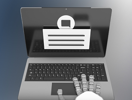 A robot hand starting to type on a laptop. 