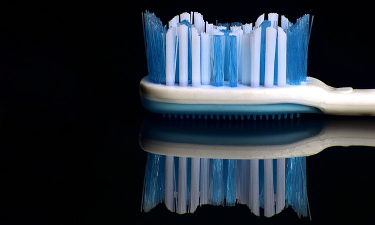 Blue and white toothbrush with a reflected on a black table